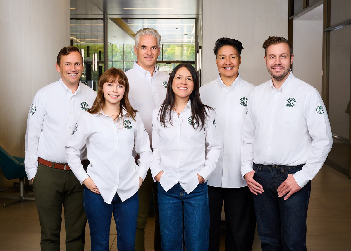 The ICT team standing together in branded shirts