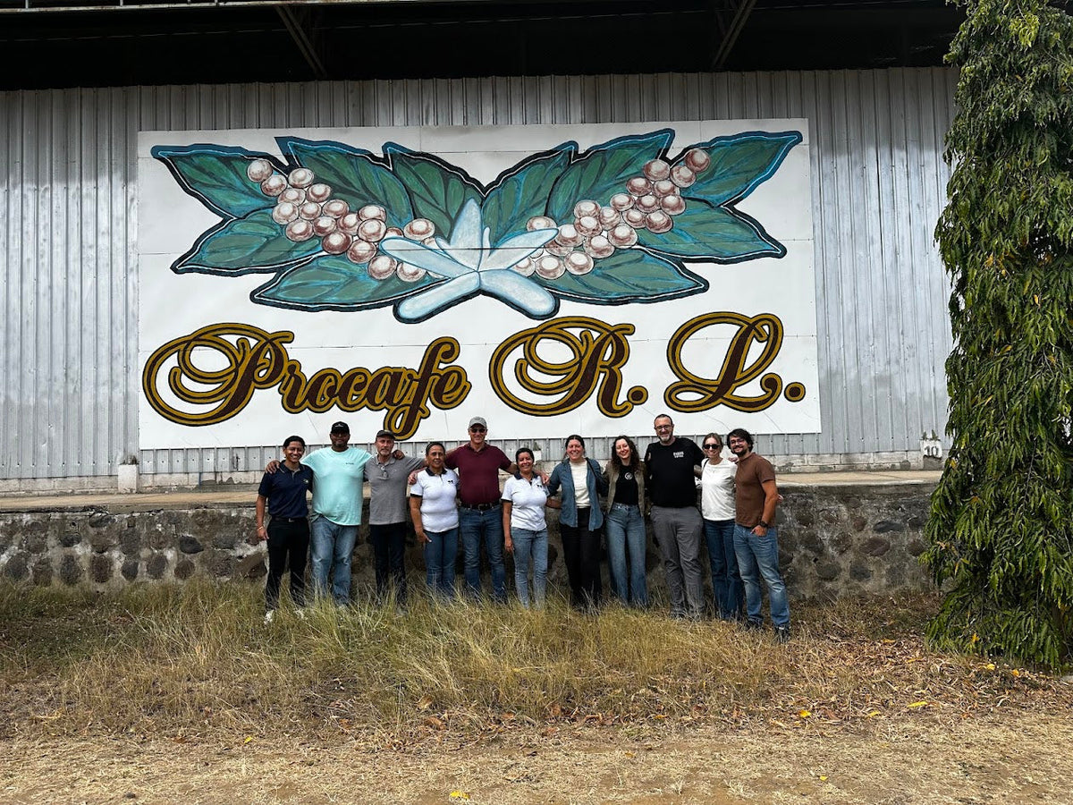 Group standing in front of the Procafé building sign