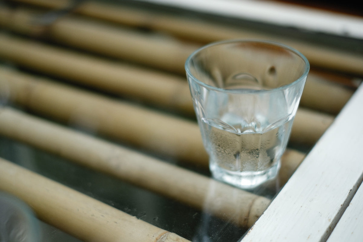 Glass of water on a bamboo-slat table